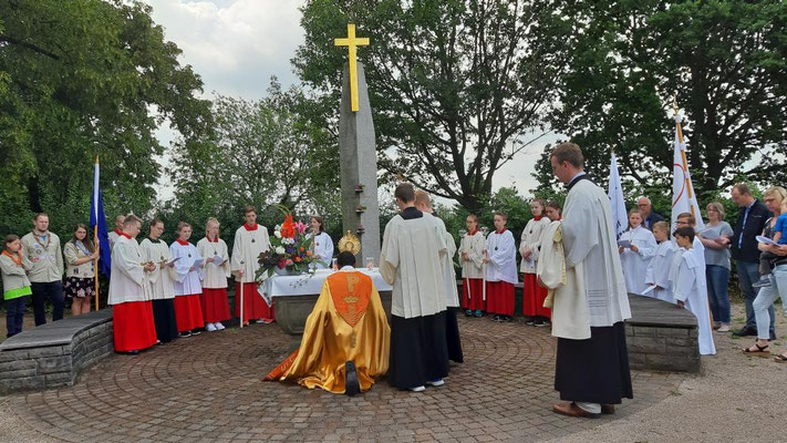 Pastor Dominik Ekweariri kniet vor dem Allerheiligsten, das auf dem Friedhofsaltar steht