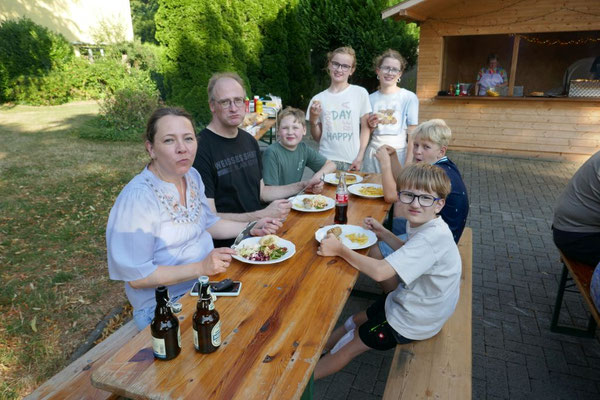 Das Foto zeigt Gäste beim Verzehr des Grillguts