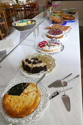 Mit Kuchen reich gedeckter Tisch