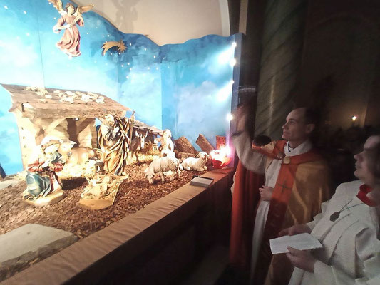 Das Fot zeigt, wie Pfarrer Schmitz die Weihnachtskrippe in unserer Kirche St. Josef segnet