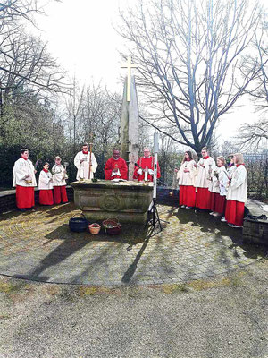 Pastor, Diakon und Messdiener am Altar auf dem Friedhof