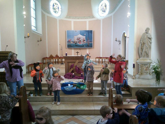 Kinder spielen die Schöpfungsgeschichte auf den Altarstufen in der Kirche St. Josef