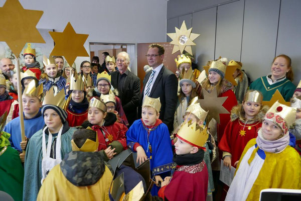 Bürgermeister Ulli Winkelmann und Beigeordneter Volker Hoven inmitten der Sternsinger