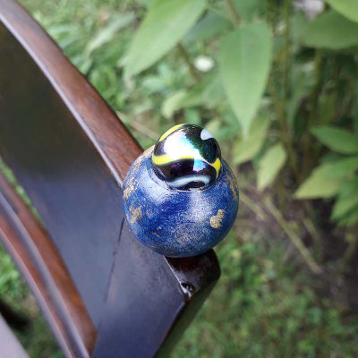 bemalte Holzkugel mit Murmel als Ornament