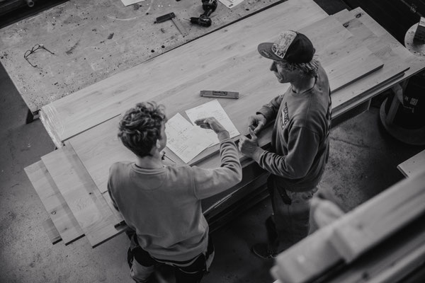 Stefan und Niklas in einer Besprechung über ein Werkstück in Werkstatt, von oben