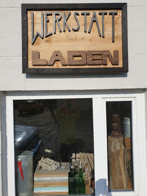 Werkstattladenschild von außen am Gebäude