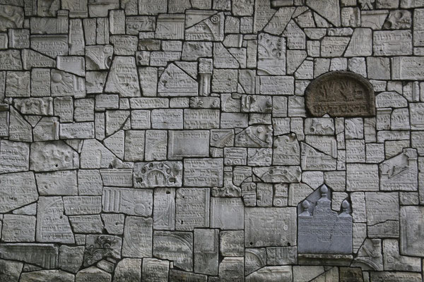 Eine Mauer aus zertörten jüdischen Grabsteinen