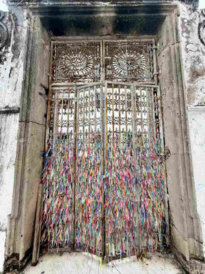Das Gittertor der Igreja de Nosso Senhor do Bonfim in Salvador, Brasilien, das mit tausenden bunten Wunschbändern geschmückt ist