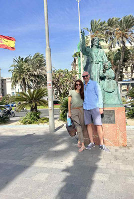 frau und mann im hafen von alicante mit statue daneben