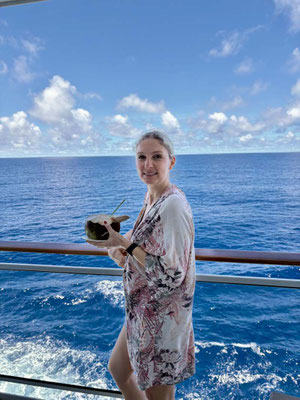 Ein weiblicher Gast auf der MS EUROPA 2 mit Kokosnuss in der Hand
