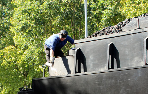 Der Lokführer kontrolliert den Wasserstand auf dem Tender der Lok 