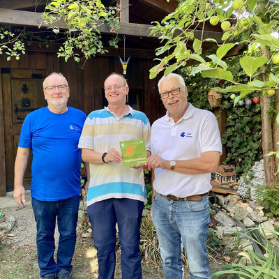 Die beiden Gartenbewerter Heinrich Wilhelm (links) und Klaus Sanzenbacher (rechts) mit dem ausgezeichneten Gartenbesitzer Udo Rathje aus Schwarzach; Foto: Mareike Rathje