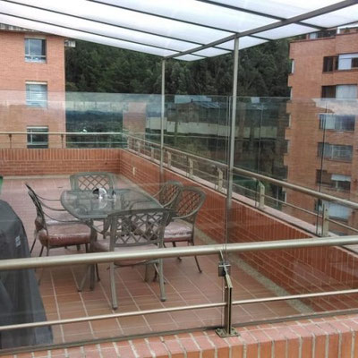 Cortavientos en vidrio templado con marquesina en policarbonato