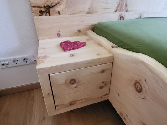 Zirbenholznachttisch am Bettrahmen befestigt
