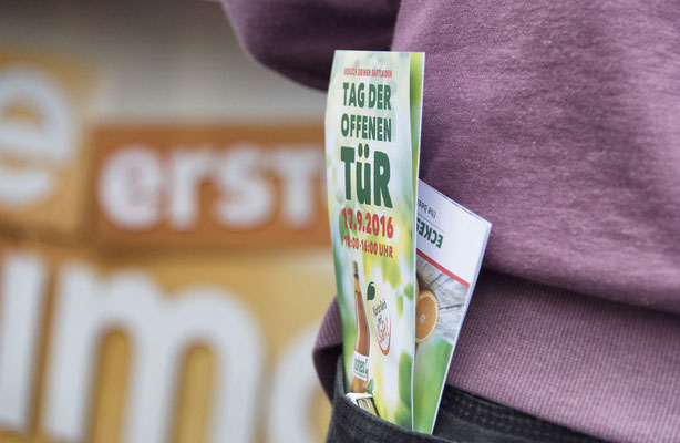 PR-Foto vom Tag der offenen Tür bei Eckes Granini, Programmflyer in der Hosentasche eines Besuchers