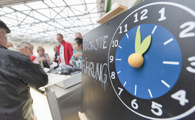 PR-Foto von der Veranstaltung Tag der offenen Tür bei Eckes Granini, eine Uhr zeigt den nächster Rundgang