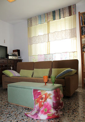 Salotto con tenda, divano e pouf