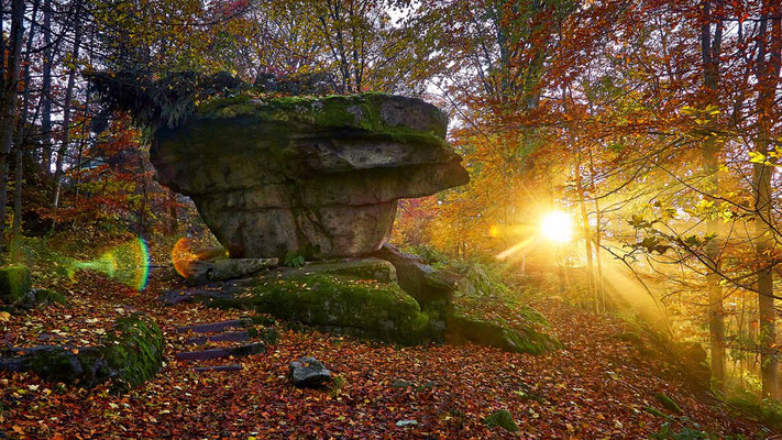 Sonnenaufgang mit Nebelstrahlen hinter dem Teufelstisch am Großen Waldstein