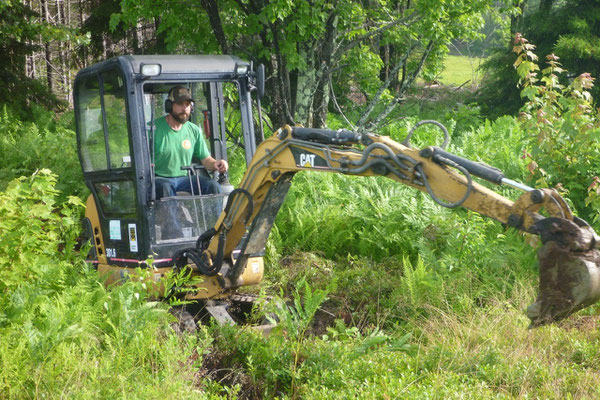 The process begins by removing the organic material with a mini-excavator