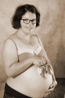 Sepiafoto, glückliche werdende Mami mit Kuscheltier über dem Babybauch, Stein AG