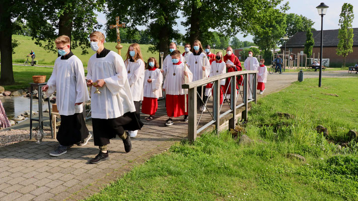 Die Messdiener mit den Priestern kommen von der Kirche ...