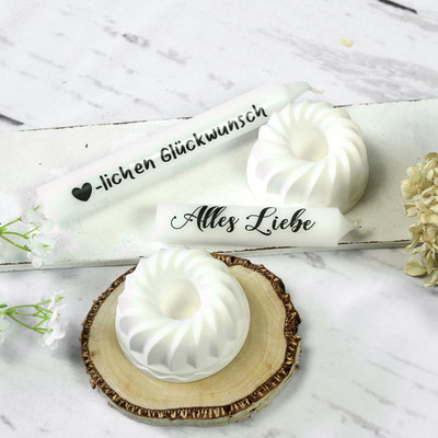 Weiße Gugelhupf-Kerzenhalter auf Holzscheibe mit Kerzen ‘Alles Liebe’, Glückwunsch.