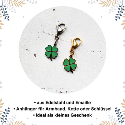 Zwei Kleeblatt-Anhänger, einer mit Silberkarabiner, einer mit Goldkarabiner, auf weißem Hintergrund.