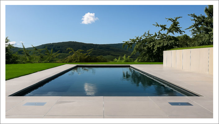 Privater Swimmingpool mit anthrazitfarbener Beckenauskleidung und klarer Beckenform im Garten.