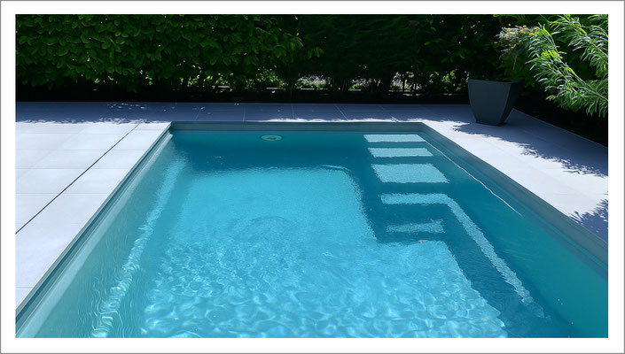 infach gehaltener privater Swimmingpool mit klarer Beckenform im Garten.