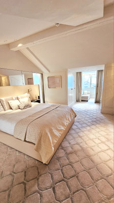 Chambre élégante et moderne de l'hôtel The Woodward à Genève, avec une décoration raffinée alliant des teintes neutres et des matériaux de haute qualité. Le mobilier soigneusement choisi crée une atmosphère chaleureuse et invitante.