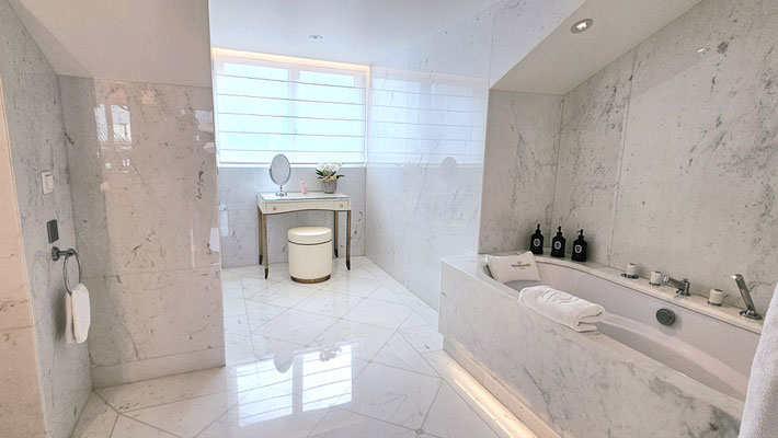 Baignoire élégante en îlot entourée de détails raffinés dans la salle de bain de la suite The Woodward, offrant une expérience relaxante et apaisante.