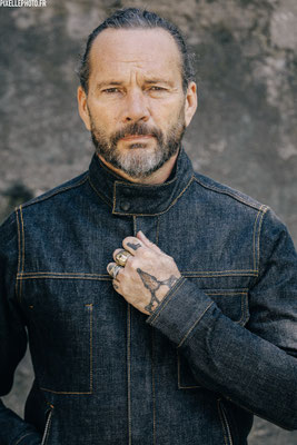 portrait d'un homme tatoué avec une veste en jean
