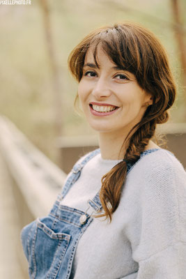 portrait d'une femme comédienne en salopette qui sourit