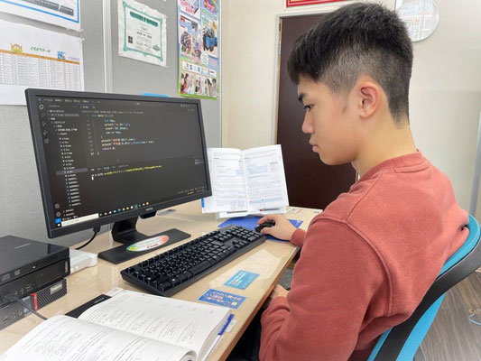 中学生男子のコードプログラミング学習風景