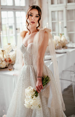 Model mit glitzer Brautkleid und Brautstrauß