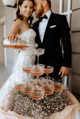 brautpaar beim feiern am hochzeitstag mit champagnerturm