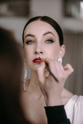 closeup maskenbuildner beim Makeup der Lippen