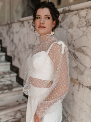 braut in outfit mit heller treppe im hintergrund