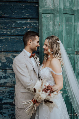 brautpaar hochzeitsfoto mit langem Kleid und Blumenstrauß
