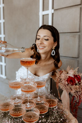 Brautmakeup und Hollywoodwellen elegante Braut mit Champagnerglas