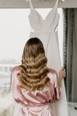 Braut vor Spiegel mit Kleid 