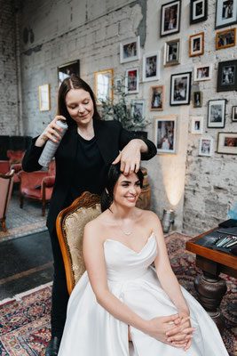 braut in keid sitzens bei haarstyling mit stylistin