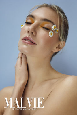 portrait blonde frau mit gelbem Augenmakeup gänseblümchen um auge