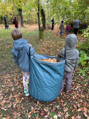 Die Kinder schleppen Laubsäcke