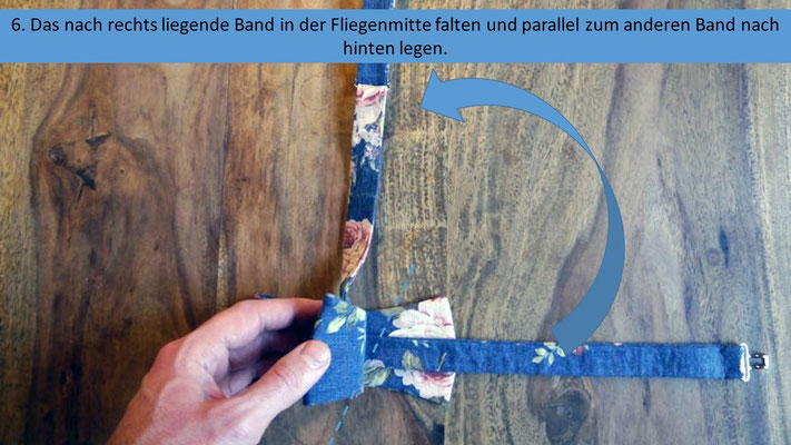 Schritt 6 der Anleitung zum Querbinder binden - Das nach rechts liegende untere Band in der Fliegenmitte falten und nach oben, parallel zum ersten Bändchen legen