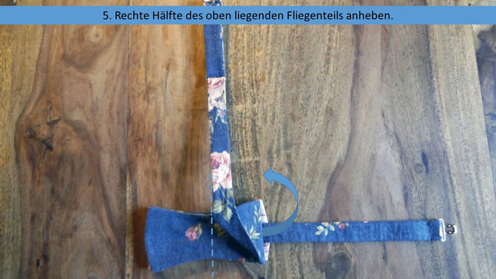 Schritt 5 der vereinfachten Anleitung zum Fliege selberbinden - Die rechte Fliegenhälfte anheben um an das Band darunter zu kommen