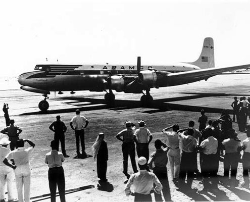 Group of people looking to the airplane The Flying Camel after landing in Dhahran 1950's