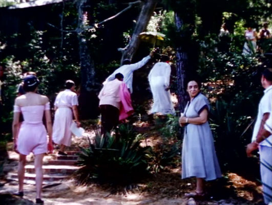 1956 ; Meher Center, Myrtle Beach, SC. ; Meher Baba walking up the steps from the bridge. Annarosa in pink summer outfit & her mother Theresa DiBlasio on the right. The images were captured by Anthony Zois from a film by Sufism Reoriented