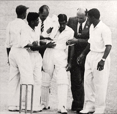 Nari Contractor is led off after being struck by Charlie Griffith
