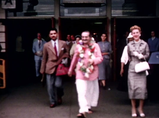 Idlewild Airport : Meher Baba outside the airport with Eruch Jessawala & Marion Florsheim ( R ). Ella Winterfeldt ( behind ) look on. Image captured by Anthony Zois from a film by Sufism Reoriented.